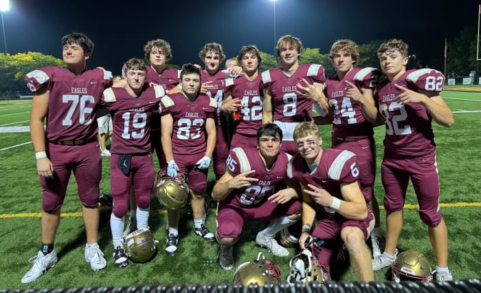 Jake Uhlenhake (No. 8) and Ben Uhlenhake (No. 42) pose with some of their teammates following a Bishop Watterson win.